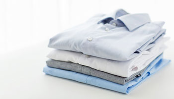 close up of ironed and folded shirts on table clothes